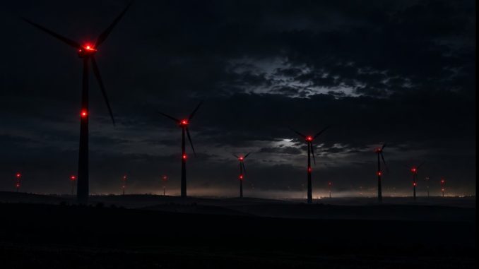 Nächtlicher Windpark mit roten Hindernislichtern. KI-generiertes Symbolbild.